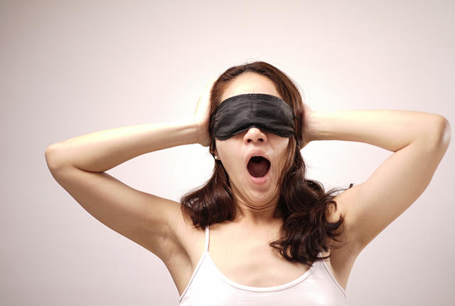 Blindfolded woman yawning