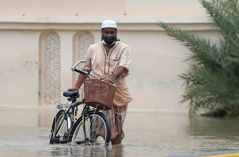 A man wades through a flooded street in Oman