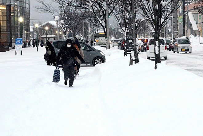 Pedestrians trudge through deep snow