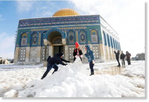 Children build a snowman in front of the Dome of the Rock, in Jerusalem’s Old City, January 27, 2022.