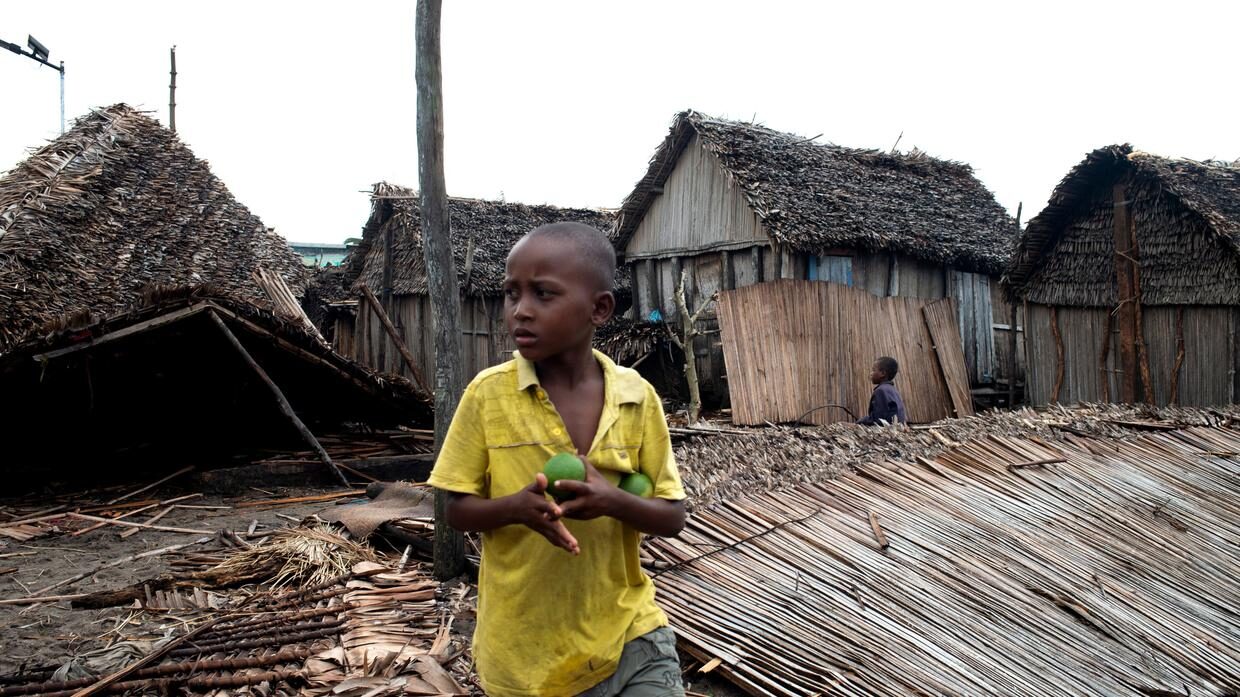 A child stands outside a ruined home in Mananjary, Madagascar