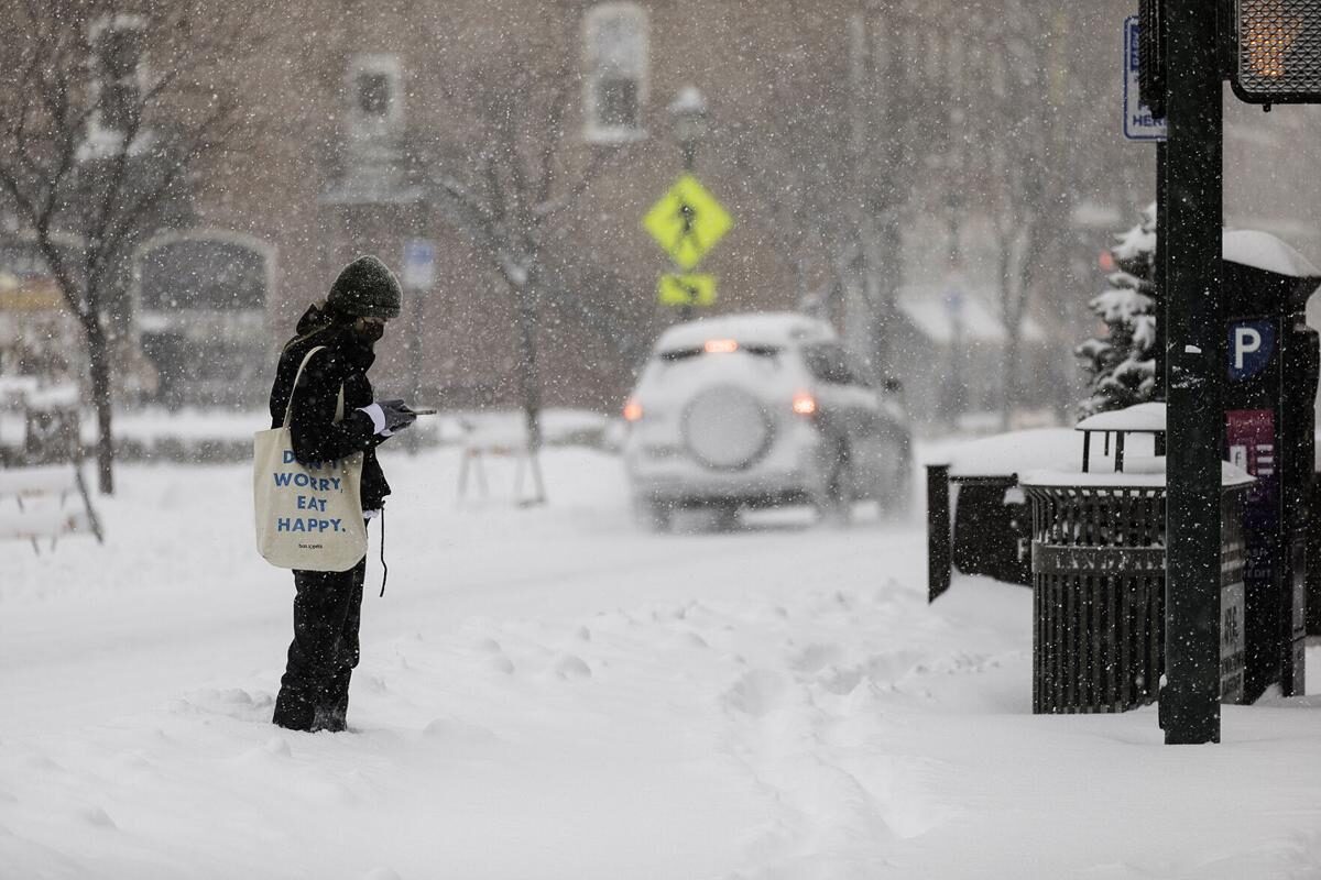 Katarina Hahn checks her phone before heading into work Wednesday morning after Flagstaff received multiple inches of snow overnight.