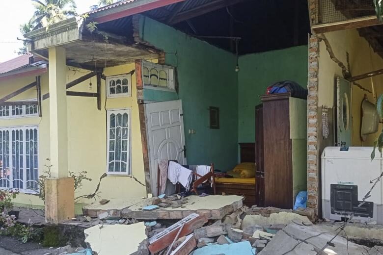 Debris is seen outside a damaged house in Pasaman, West Sumatra, after a 6.2-magnitude earthquake struck the area on Feb 25, 2022.