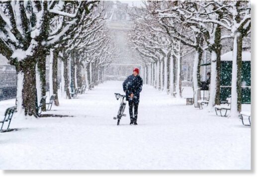 A person walks their bike through the snow in the Swiss canton of Zurich.