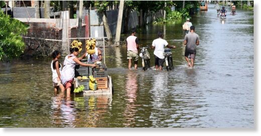 A vendor wades through a flooded street, in Kamrup distric of Assam, June 24, 2022.