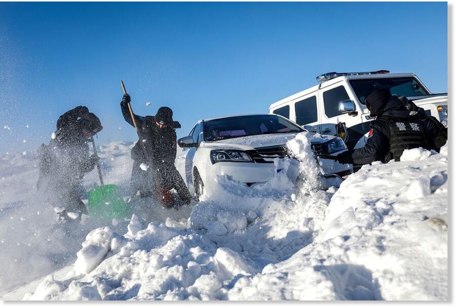 Police officers help a car stuck in the snow in Fuyun county, Xinjiang Uighur Autonomous Region, China February 18, 2024.