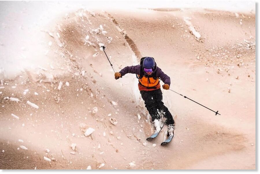 A young skier in the Corviglia Ski Area in St. Moritz, Switzerland, skiing down sand-covered snow.