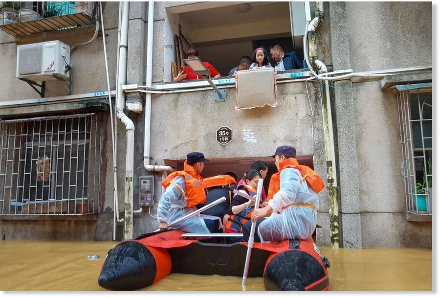 Shaoguan emergency workers help stranded residents evacuate their home on Saturday.