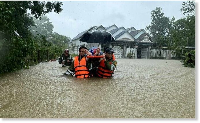 Soldiers wade through a flooded street on Phu Quoc Island to carry a patient to hospital, July 14, 2024.