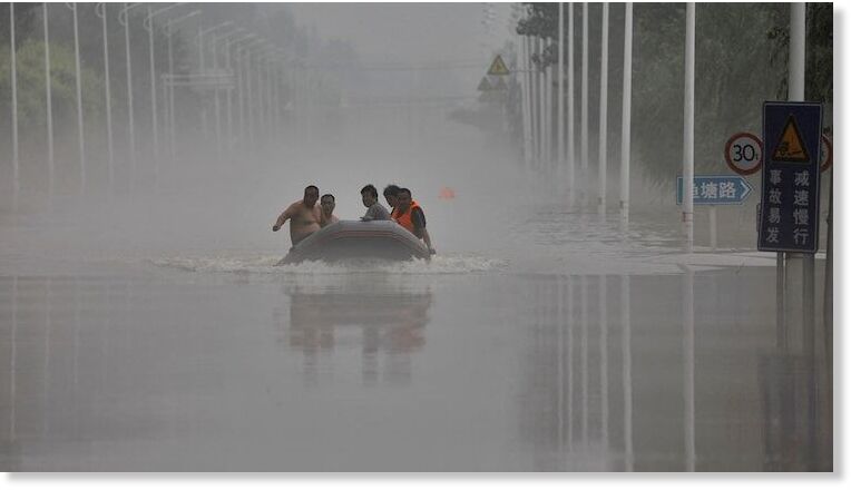 People ride a boat through a flooded
