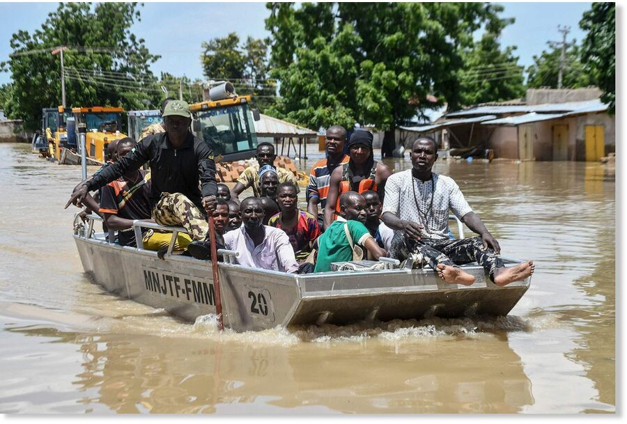 People affected by floods are escorted through flood water on a military boat in Maiduguri, Nigeria, September 12, 2024.