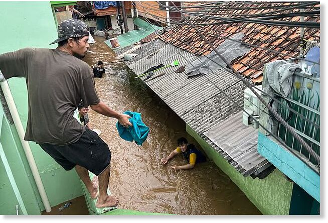 Residents look to evacuate during severe flooding in Jatinegara district in Jakarta.