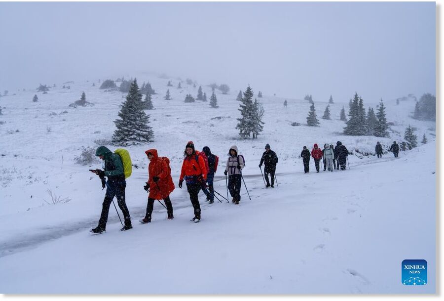 People walk in a snowfall in the Northern Velebit National Park, Croatia, on May 23, 2025.