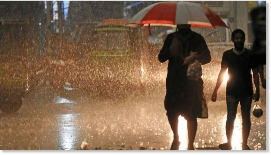 People on their way at a road during heavy rain in day hours in Rawalpindi on May 24, 2025.