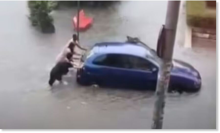 Residents were forced to push cars through the flood.