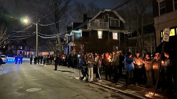 A crowd of people holding candles gather outside the home of Massachusetts Institute of Technology professor Nuno F.G. Loureiro