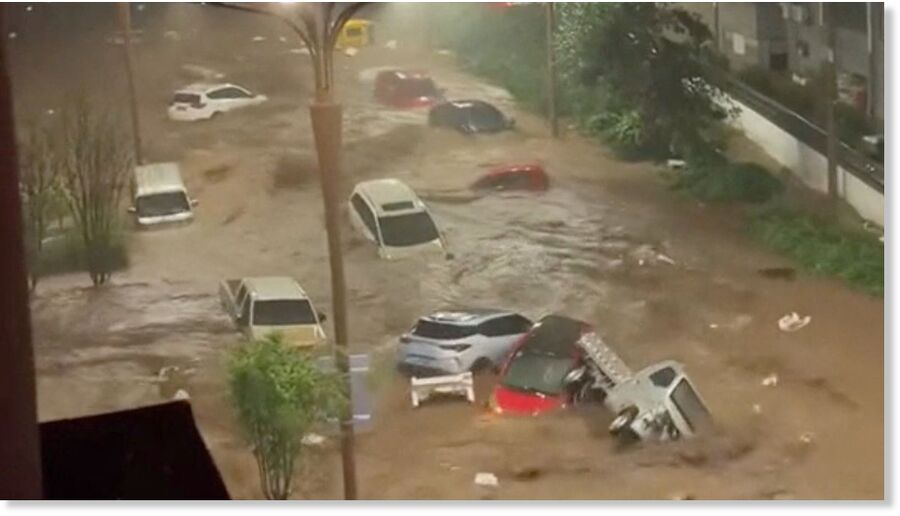 Vehicles are swept away by flooding in Hebei Province.