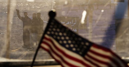 Iraqis wave as the last U.S. convoy heads